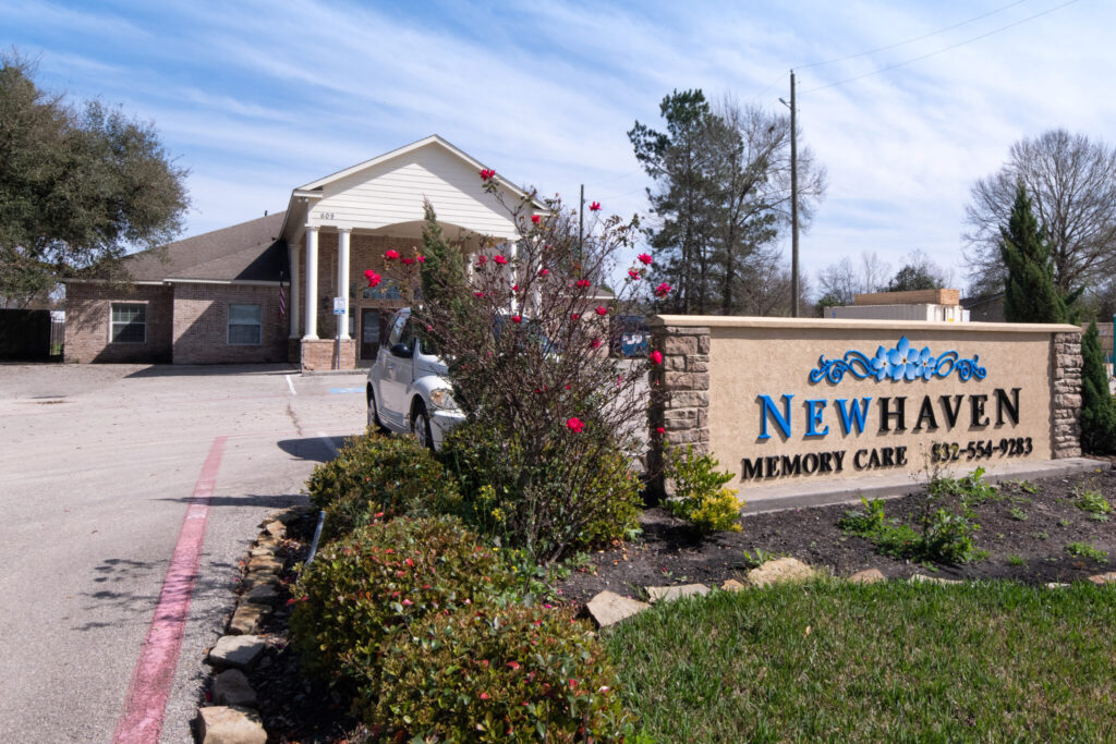 Front view of New Haven Assisted Living and Memory Care facility in Tomball, TX, featuring the facility's sign, parking lot, and front entrance.