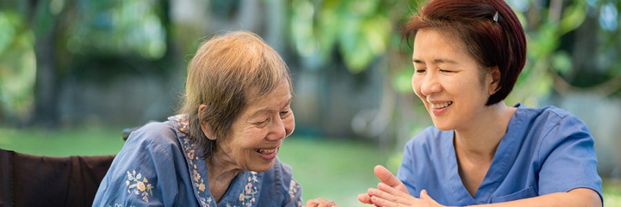 Elderly woman with caregiver in the needle crafts occupational therapy  for Alzheimer’s or dementia